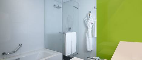 A modern bathroom with a bathtub, a shower, and a sink.