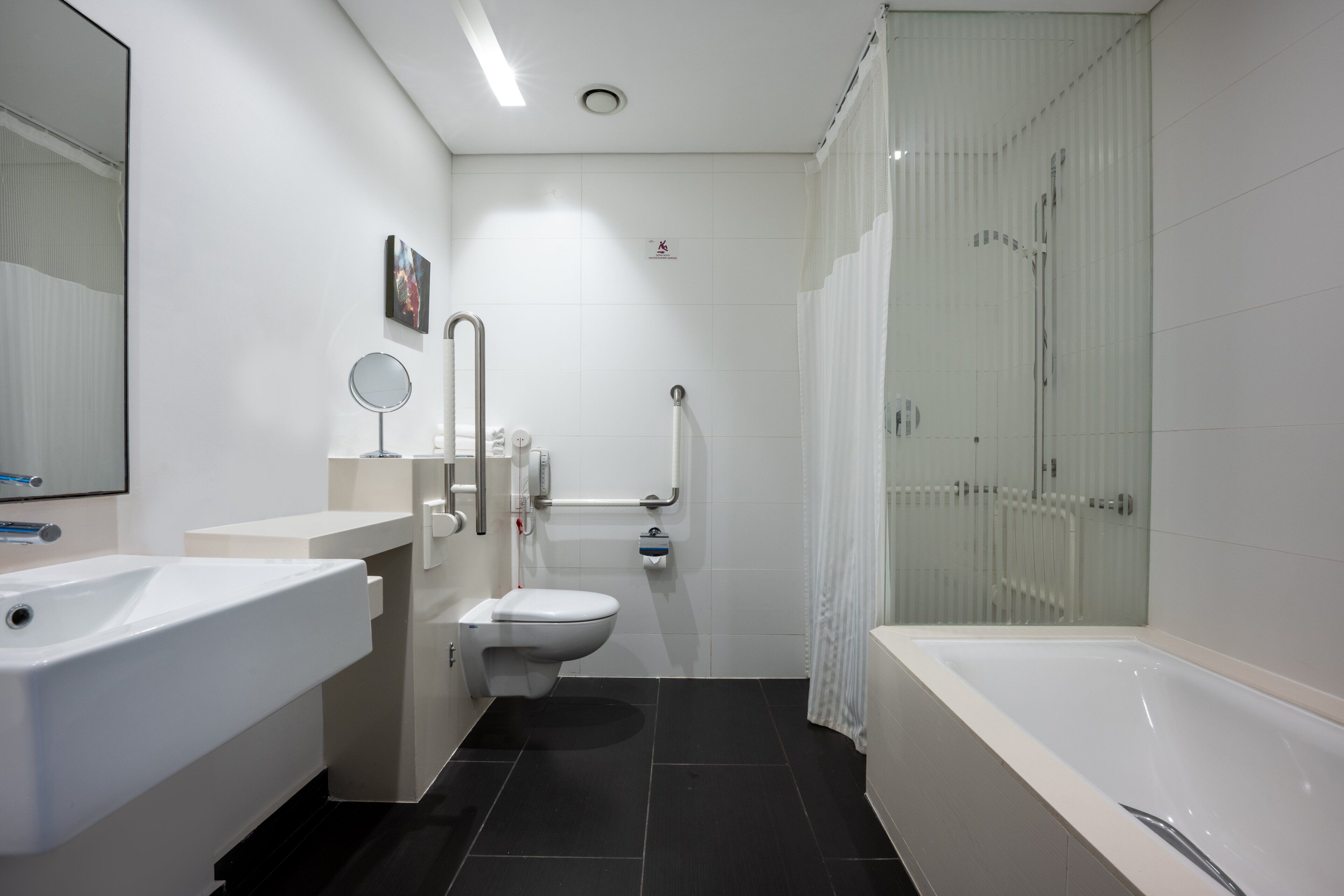 A modern bathroom with a bathtub, toilet, and sink.