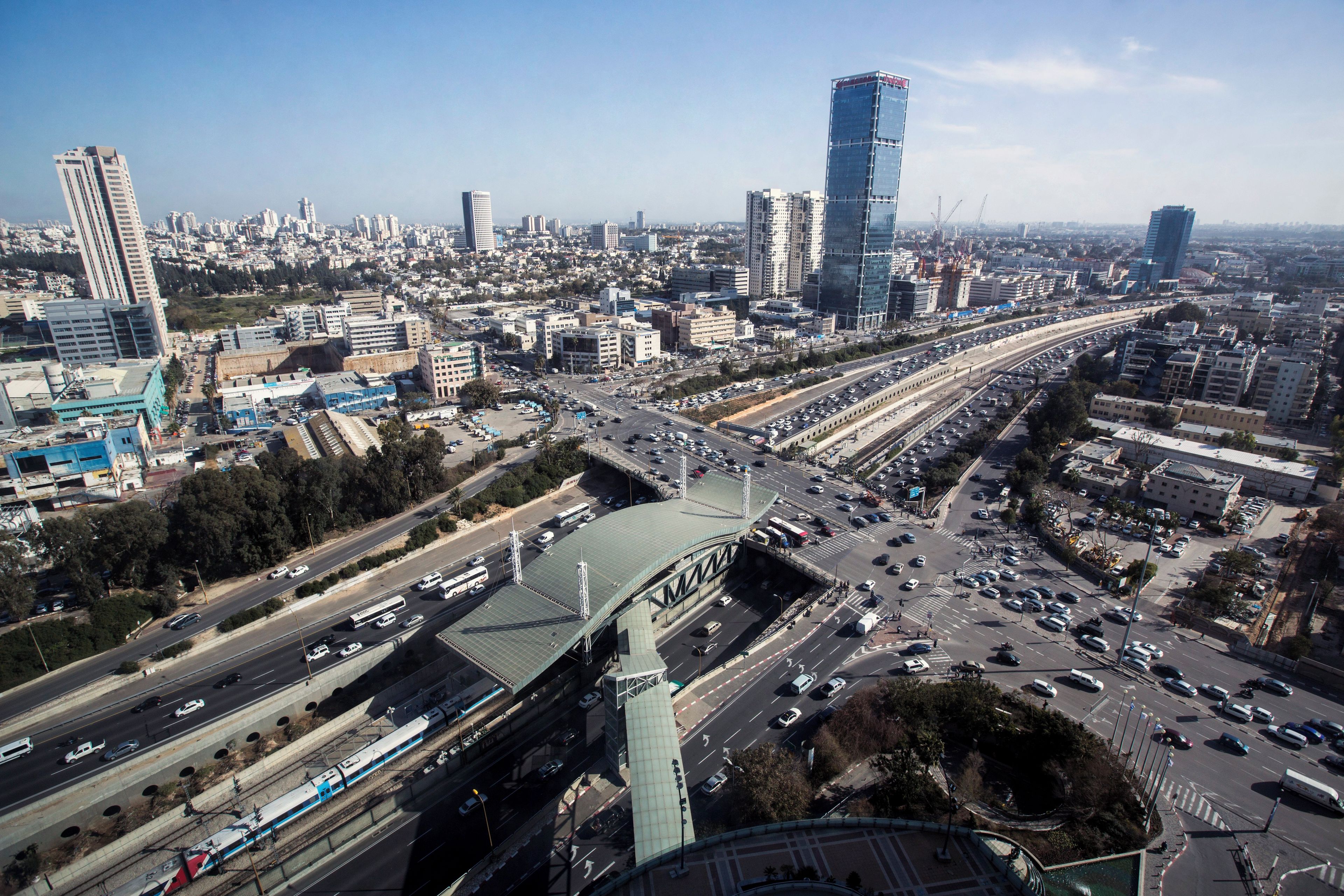 A cityscape with a prominent highway interchange and multiple high-rise buildings.