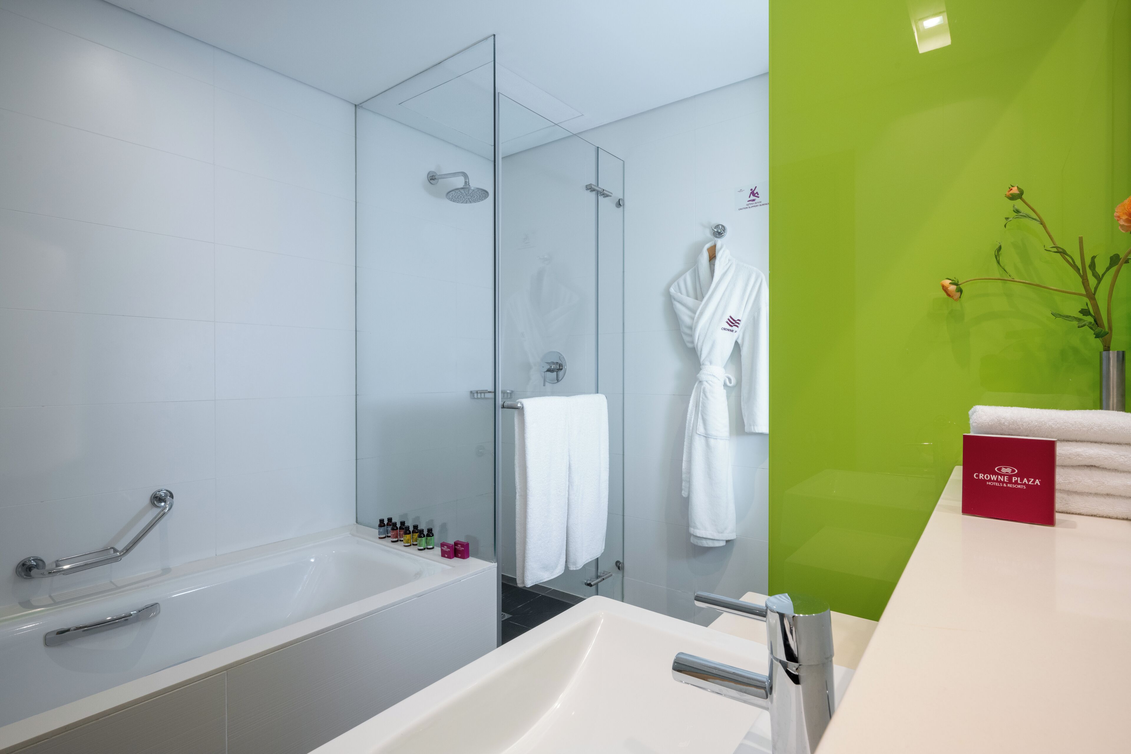 A modern bathroom with a glass shower, a bathtub, and a vanity with a mirror.