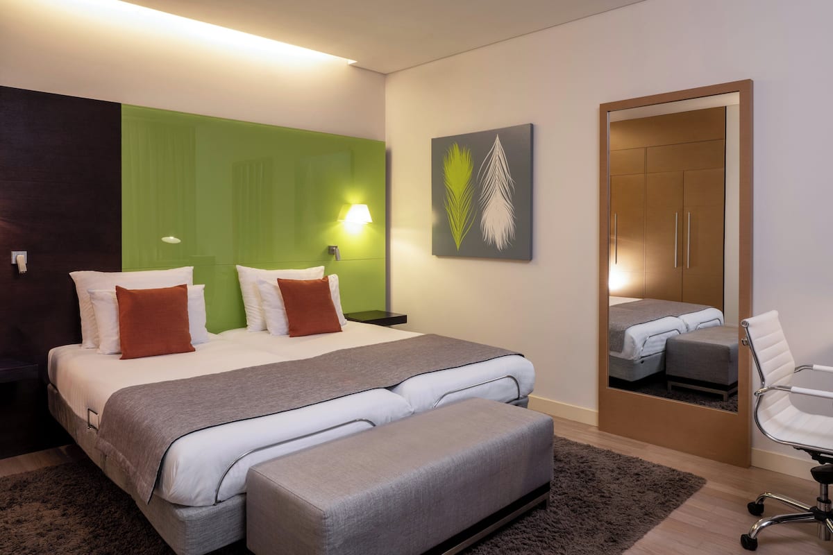 Een moderne hotelkamer met een groot bed, een bank, een bureau en een stoel.