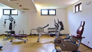 Una palestra con diverse attrezzature per esercizi, tra cui una cyclette ed attrezzi per pesi.