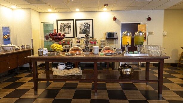 A breakfast buffet with various food items and beverages, a microwave, and a coffee station. - Hampton Inn by Hilton Guadalajara-Aeropuerto (El Salto)