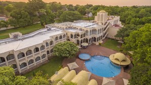 Un edificio grande con varios balcones, una piscina y una estructura en forma de cúpula.