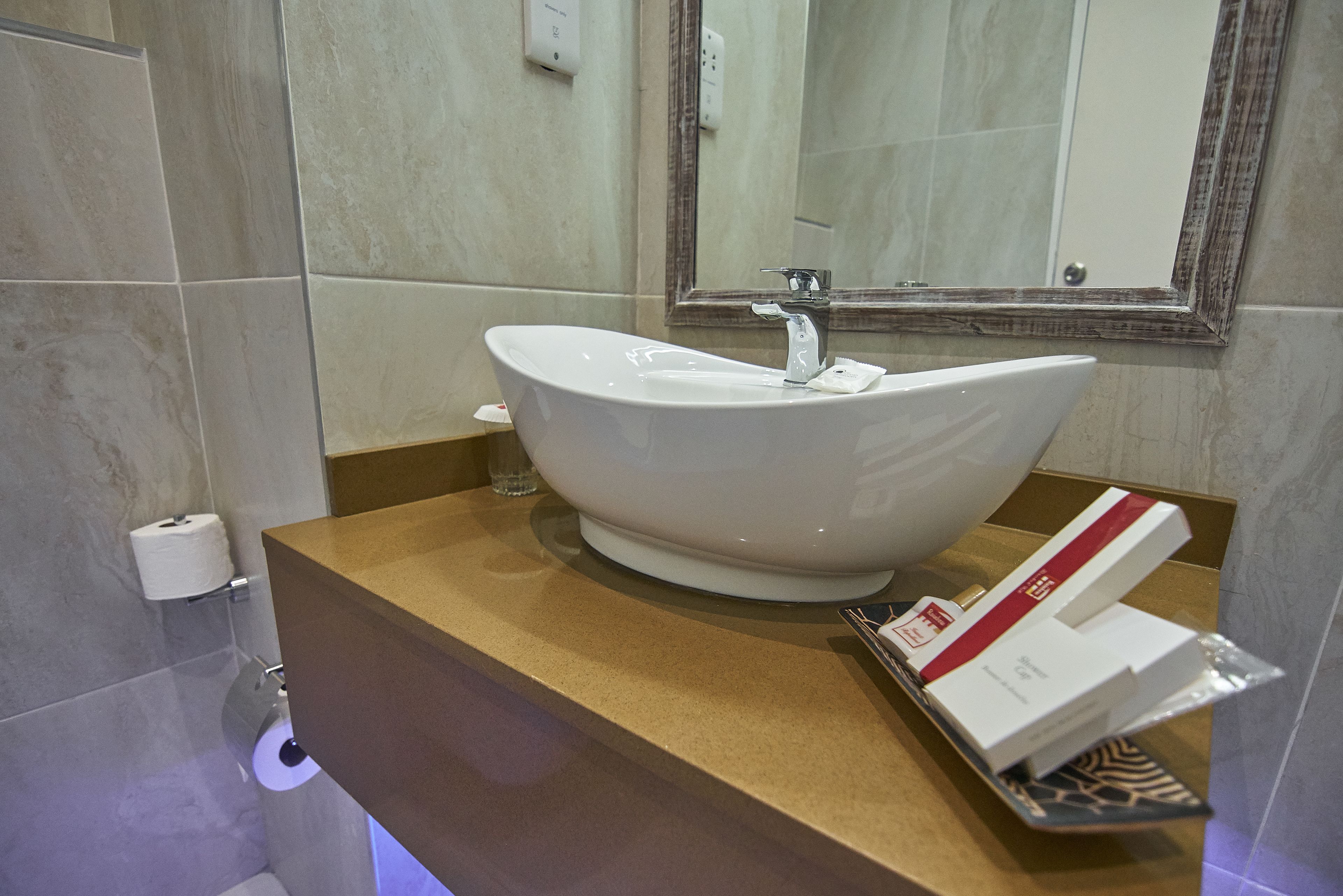 A bathroom with a white sink, a mirror, and a towel rack.