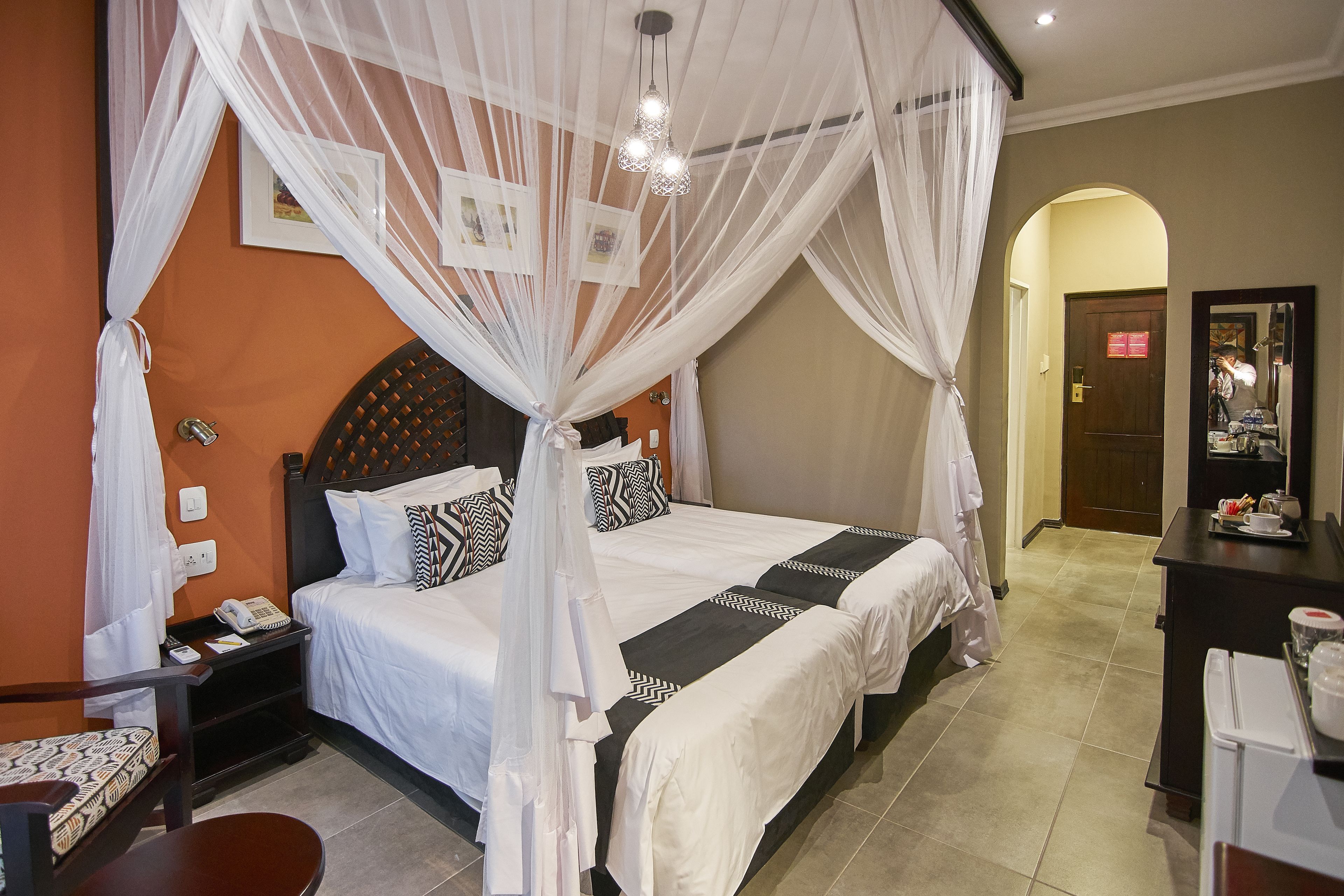 A hotel room with a bed, a nightstand, a desk, and a chair.