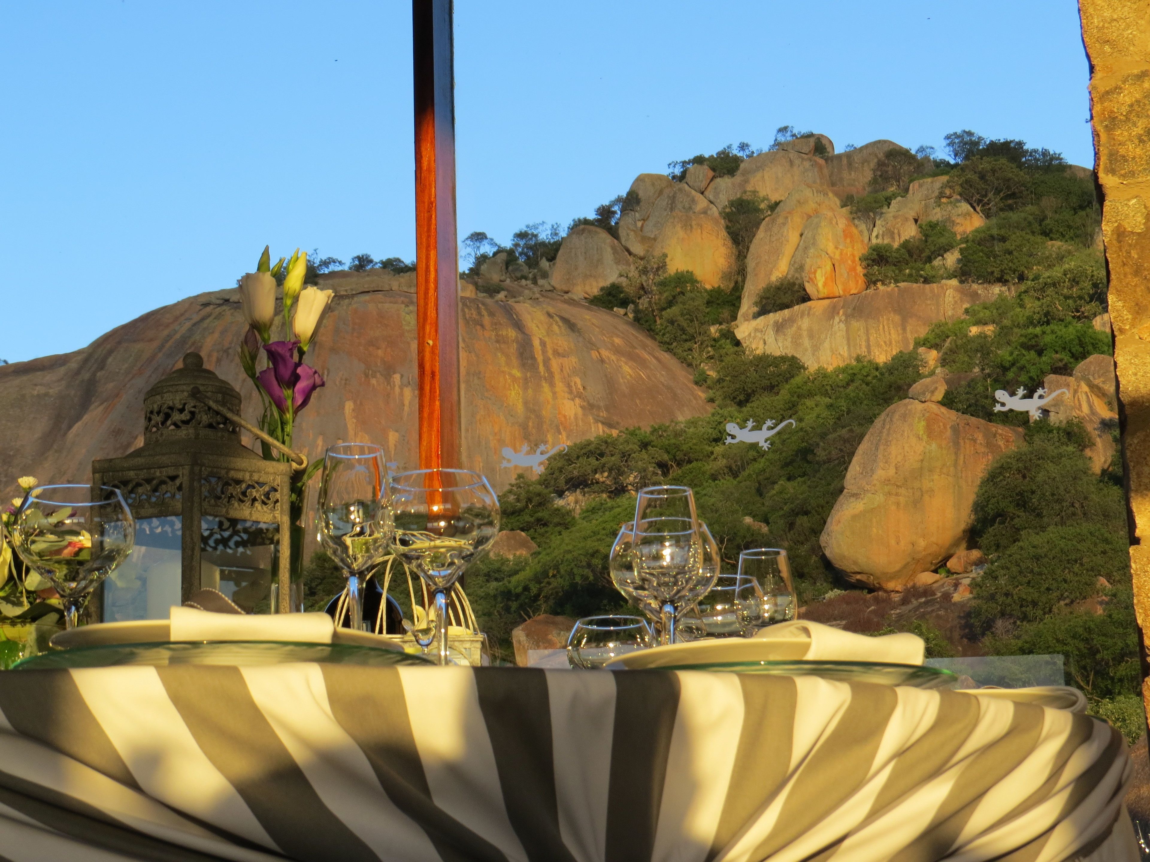 Mesa al aire libre con vistas a colinas rocosas y vegetación.