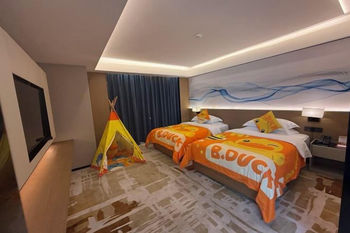 Habitació d'hotel amb dos llits, una tenda i un quadre abstracte gran a la paret.