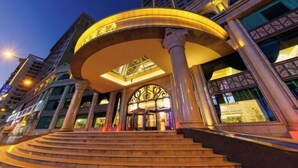 A grand hotel entrance with a large, illuminated archway and a set of stairs leading up to it. - Foshan Sanshui ShiHuang Garden Hotel (Foshan)