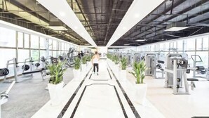 A gym with exercise equipment, potted plants, and a marble floor. - Foshan Sanshui ShiHuang Garden Hotel (Foshan)