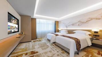 A hotel room with a large bed, a TV mounted on the wall, and a marble wall.