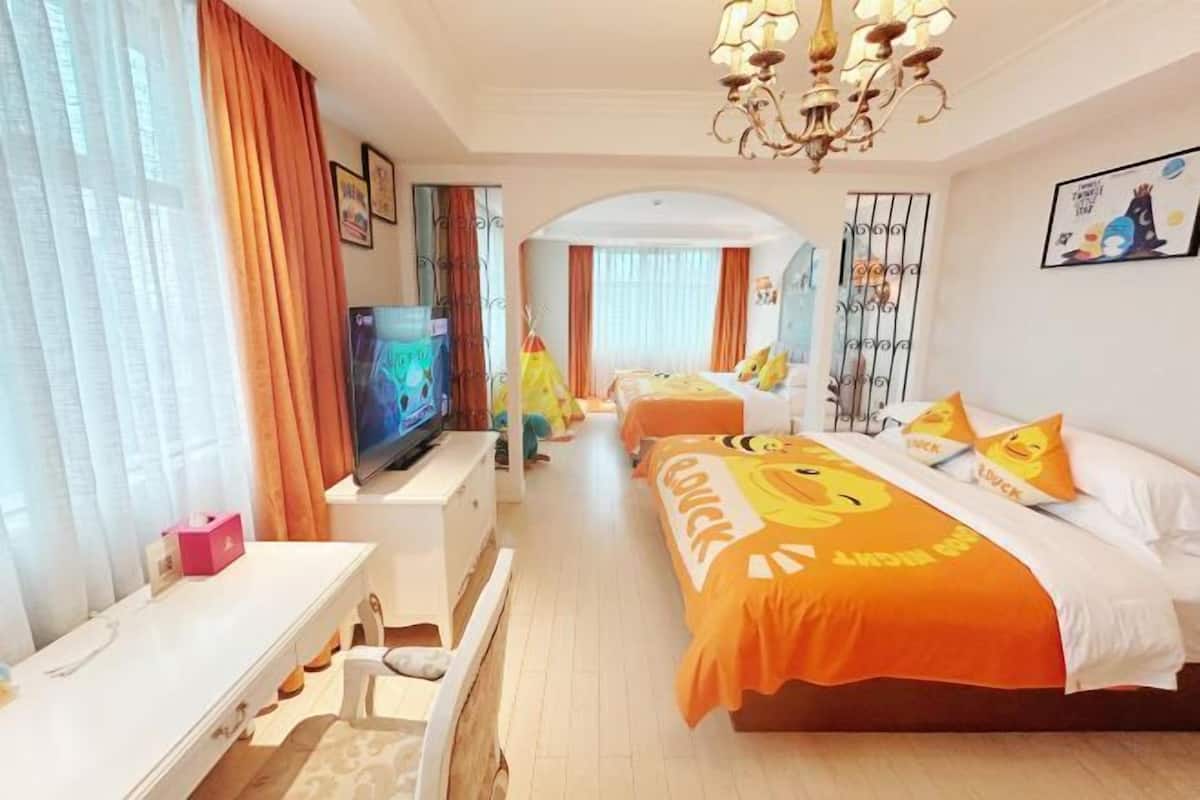 A hotel room with a large bed, a television, a desk, and a window with curtains.