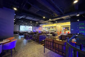 A bar area with seating and a projection screen. - Foshan Sanshui ShiHuang Garden Hotel (Foshan)
