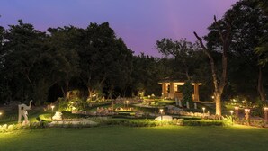 A landscaped garden with a gazebo, pathways, and illuminated garden lights. - Heritage Village Resort & Spa Manesar (Gurugram)