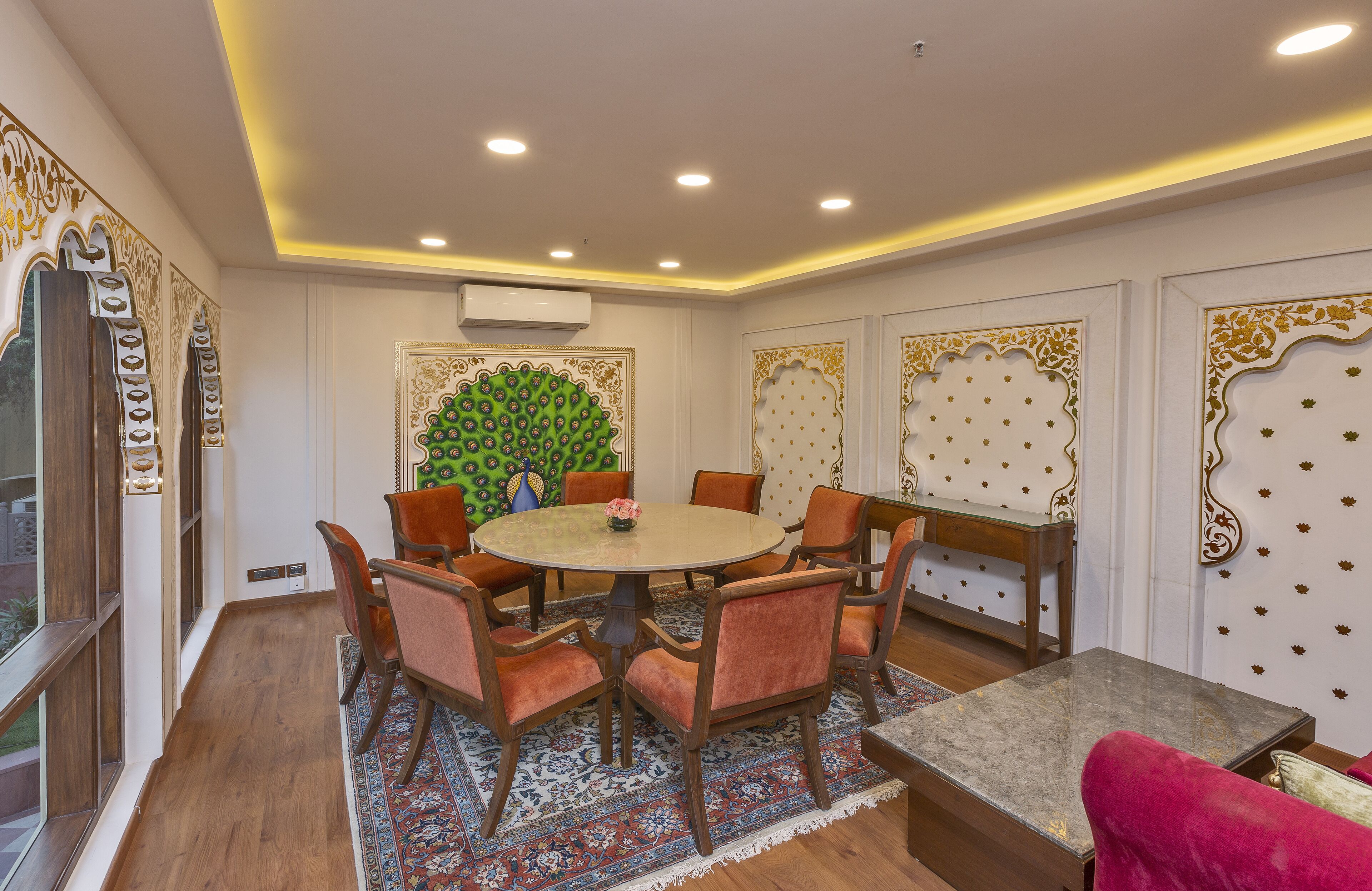 A dining area with a round table, six chairs, and a bench.