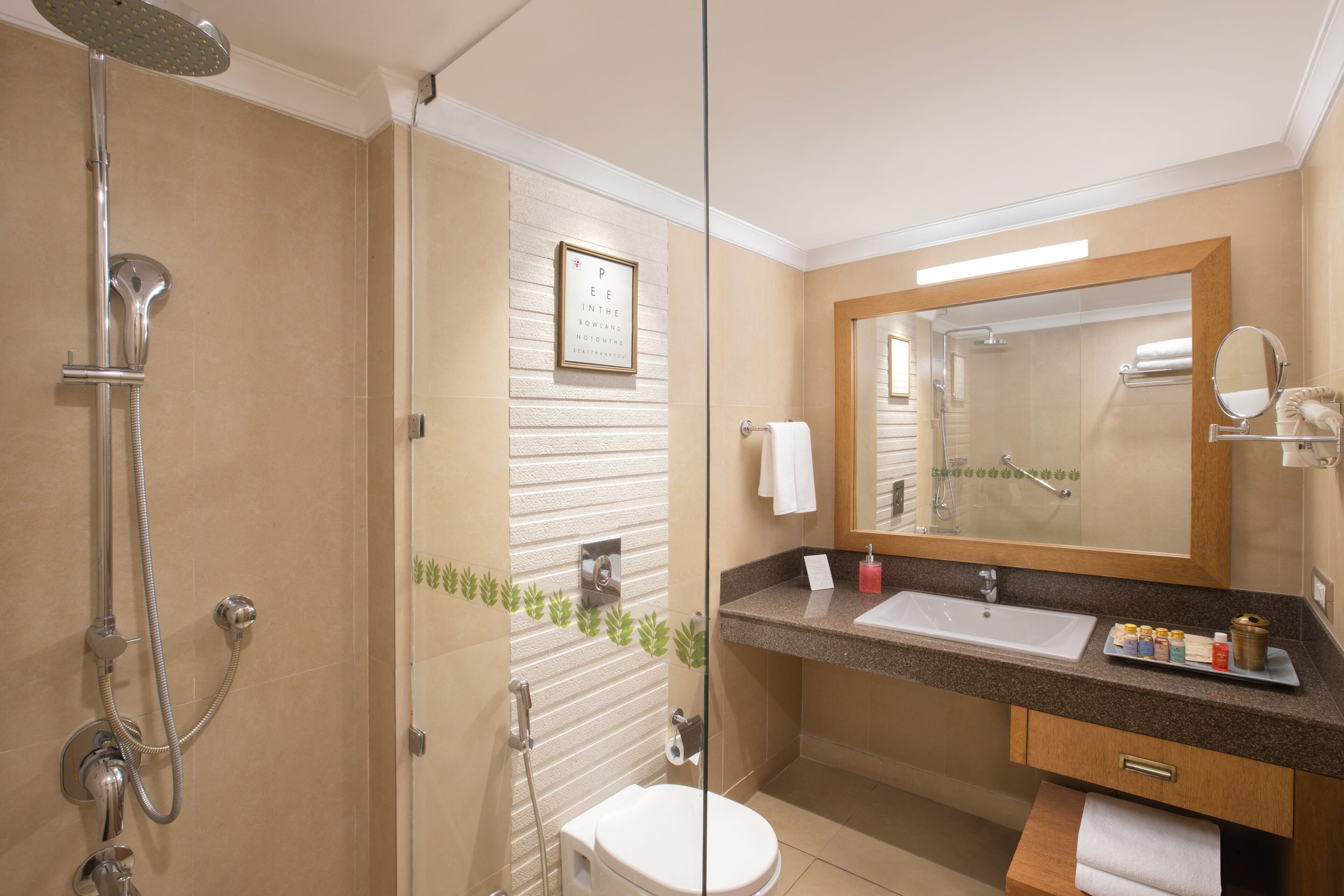 A modern bathroom with a glass-enclosed shower, a sink with a vanity, and a large mirror.