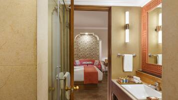 Un baño de hotel con un espejo grande, un lavamanos y una zona de ducha.
