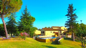 A two-story house with a swimming pool, surrounded by trees and a clear blue sky. - Il Molino del Ponte (Montespertoli)