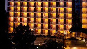 A multi-story hotel with balconies, a central courtyard, and a modern architectural design. - Helios Spa (Golden Sands)