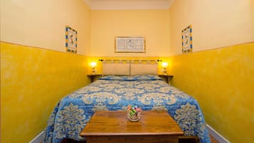 Una habitación con una cama, dos lámparas de noche, una mesita de noche y un cuadro colgado en la pared.
