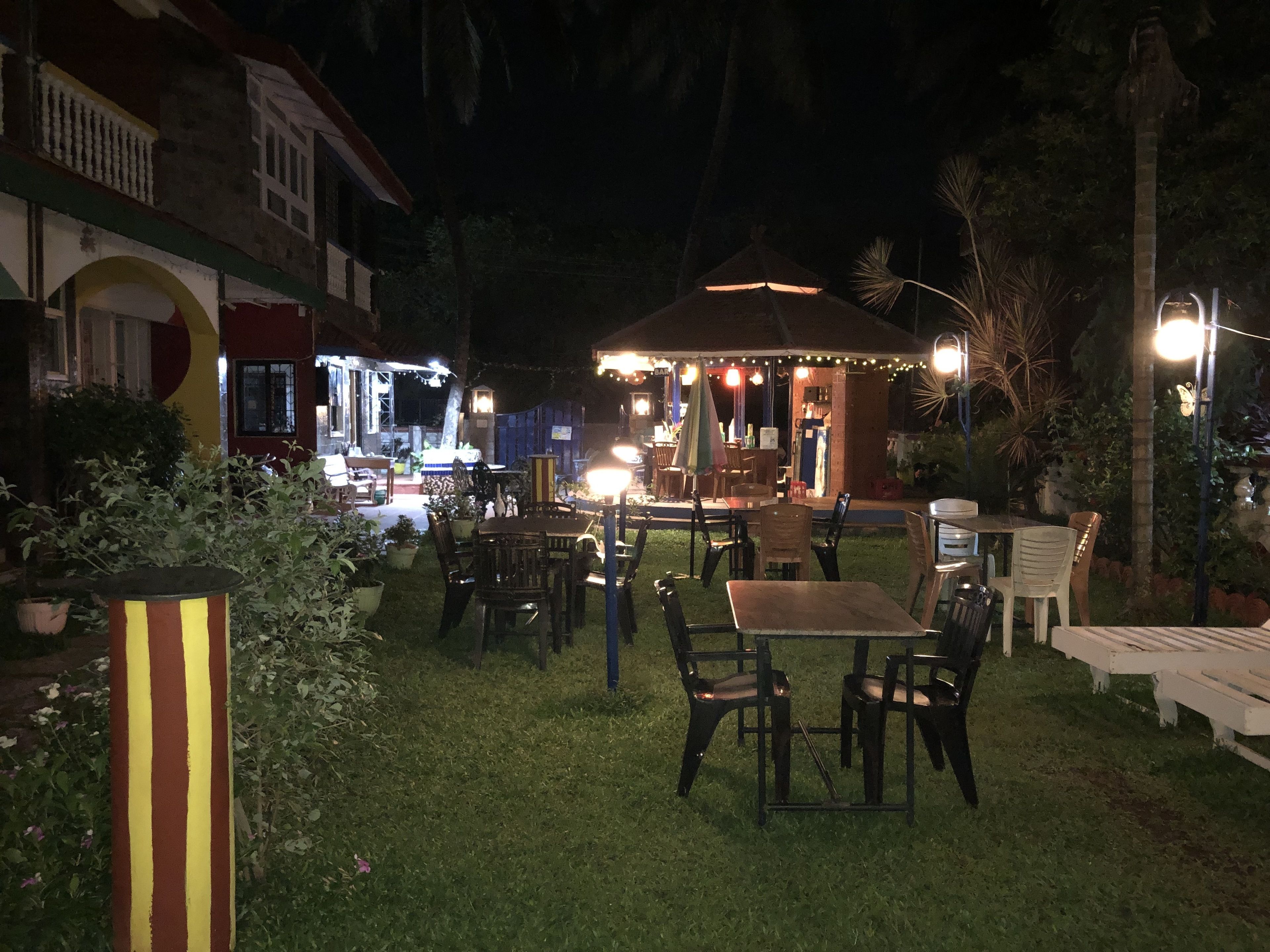 An outdoor patio area with tables and chairs, a gazebo, and string lights.