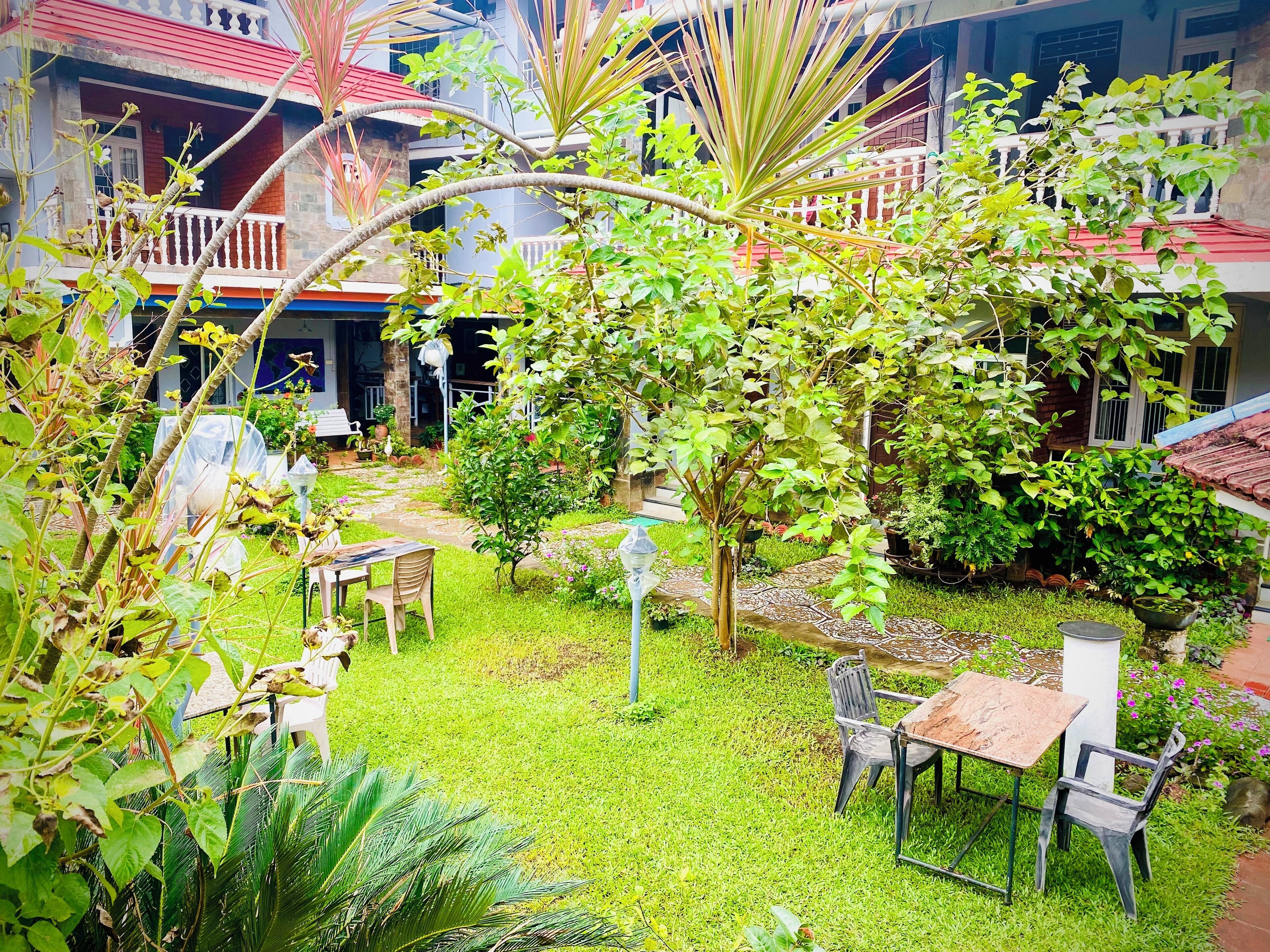 A courtyard with a small garden, a table, and chairs.