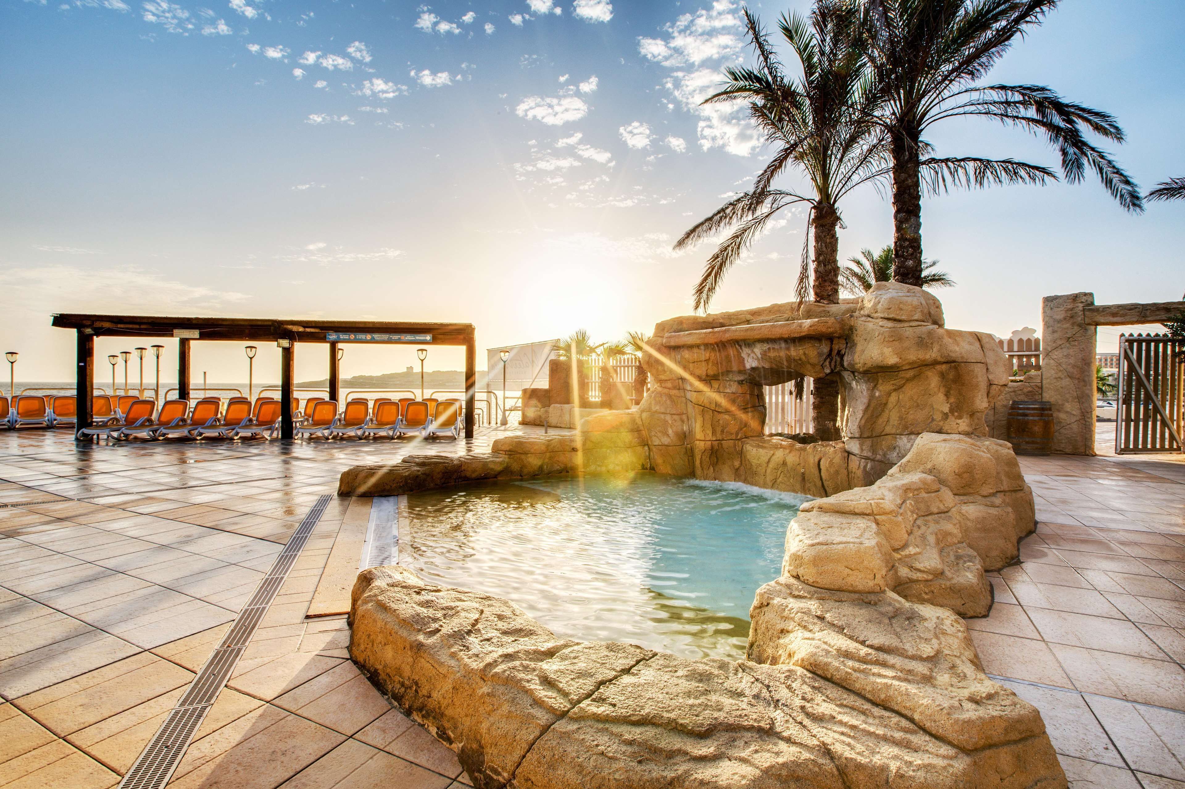 Una piscina techada, una piscina al aire libre de temporada, sombrillas