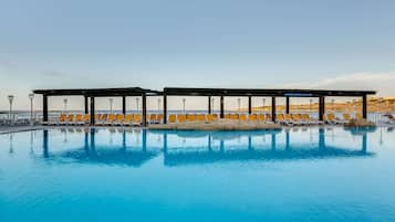 Una piscina cubierta, una piscina al aire libre de temporada, sombrillas