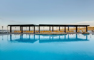 Una piscina techada, una piscina al aire libre de temporada, sombrillas