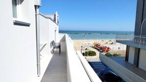 Ein Balkon mit Blick auf Strand und Meer.
