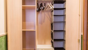 A walk-in closet with open doors, featuring multiple shelves, hanging space, and drawers. - Residenza Ki - Bed & Breakfast (Rome)