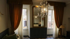 A hotel room with a bed, a large mirror, a chandelier, and a patterned floor. - Residenza Ki - Bed & Breakfast (Rome)