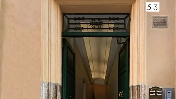 A building entrance with a green door, a number '53' sign, and a mail slot on the wall. - Residenza Ki - Bed & Breakfast (Rome)