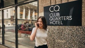 A sign for CQ Club Quarters Hotel.