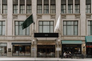 A building with a sign reading "111" and "III West Adams Street" indicating a pub and restaurant. - Central Loop Hotel (Chicago)