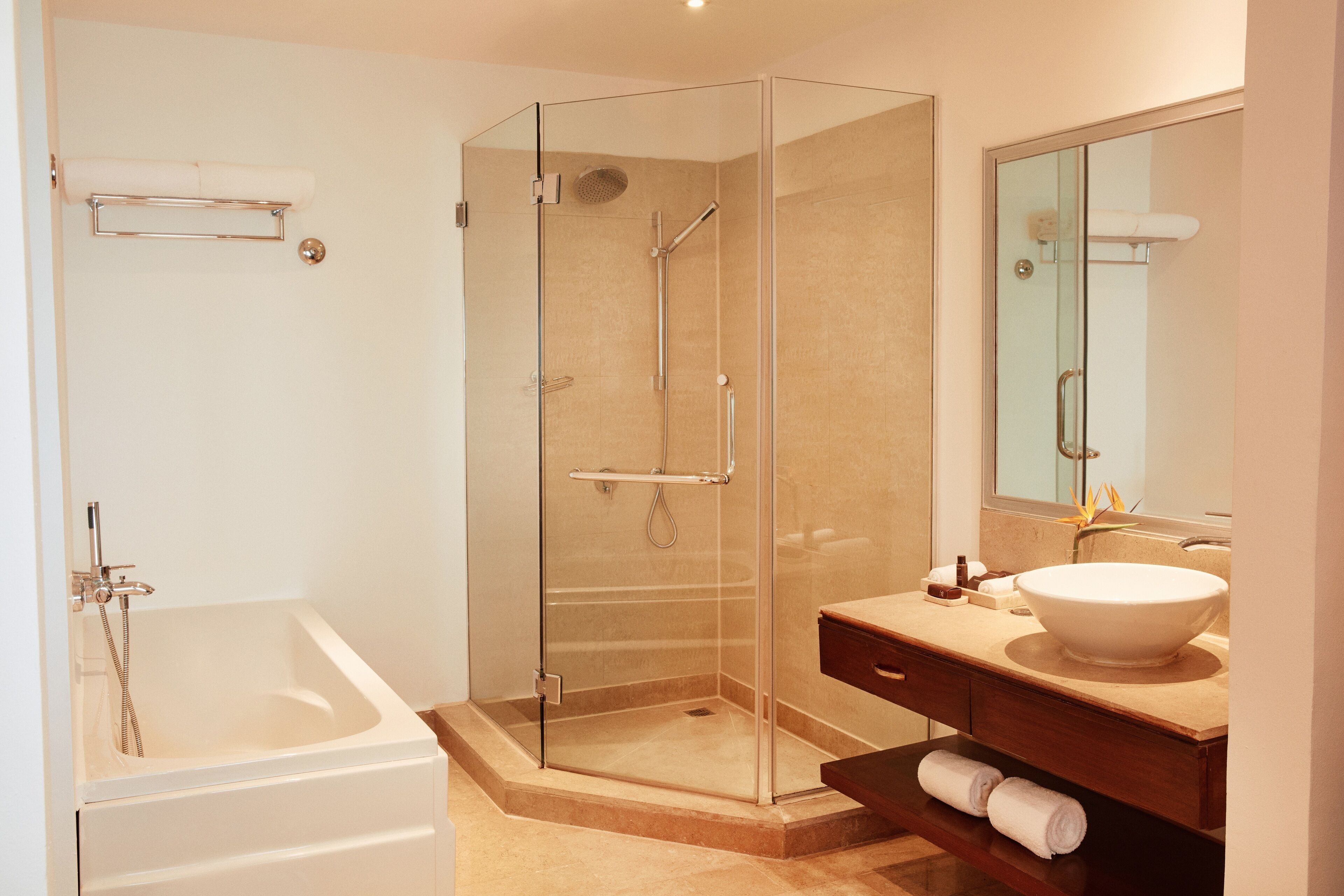 A modern bathroom with a glass-enclosed shower, a standalone bathtub, and a vanity with a large sink.