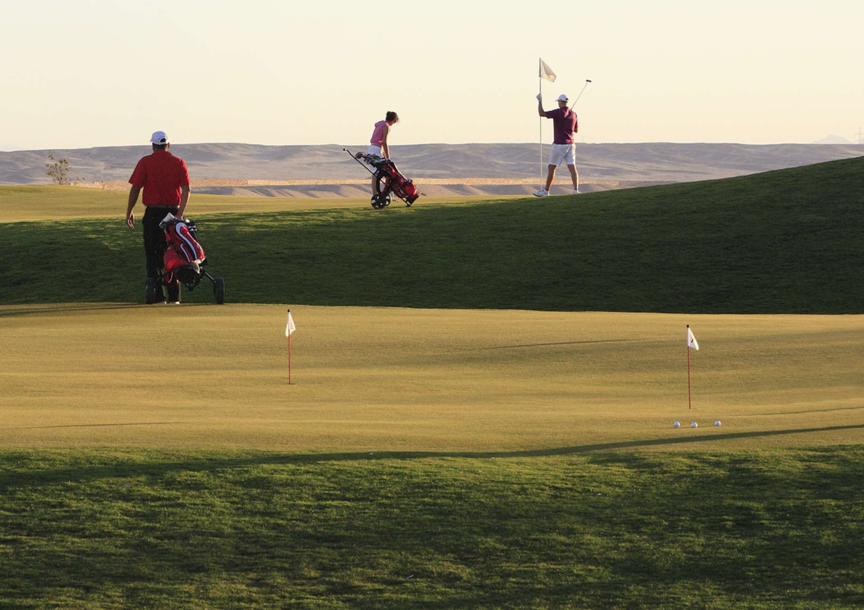 Un campo de golf con vistas despejadas al green, los fairways y colinas distantes.