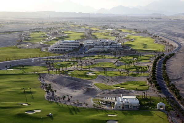 Ein Golfplatz mit Clubhaus, mehreren Gebäuden und Wüstenlandschaft.