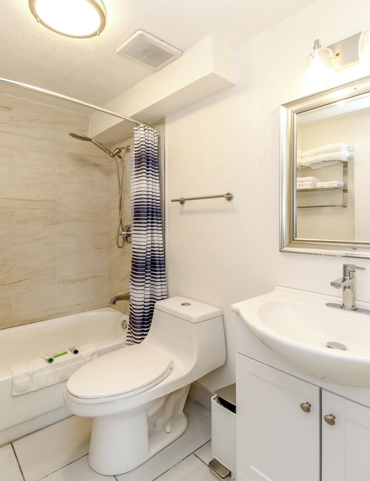 A modern bathroom with a bathtub, toilet, and sink.