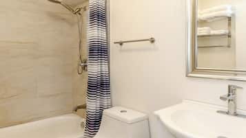 A modern bathroom with a bathtub, toilet, and sink.