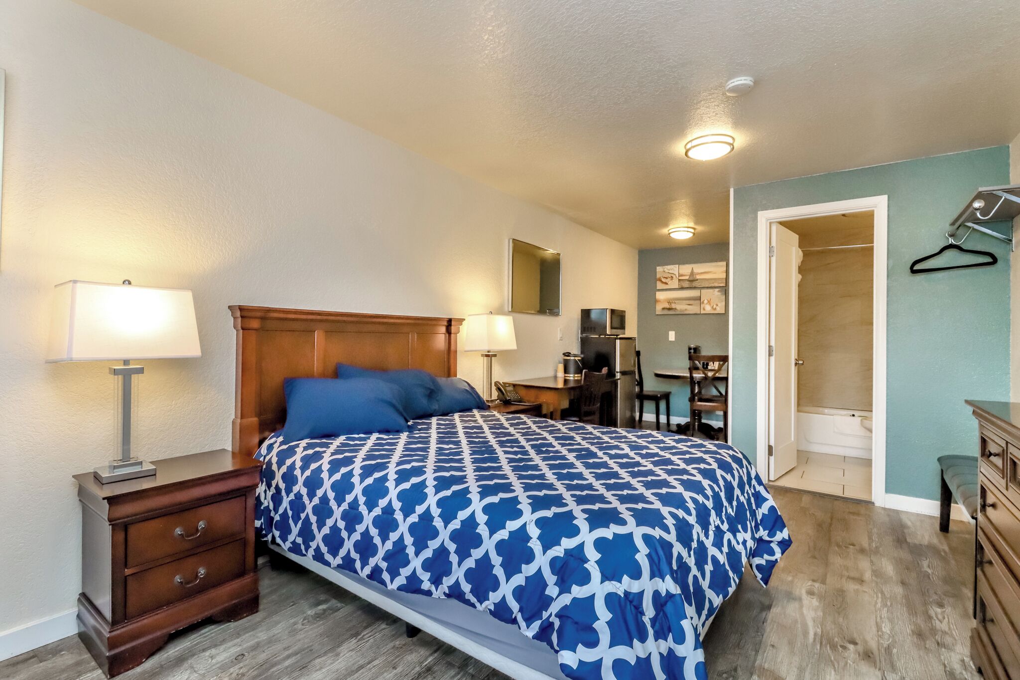 A bedroom with a bed, bedside tables, a desk, and a walk-in closet.