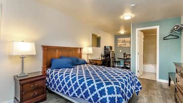 A bedroom with a bed, bedside tables, a desk, and a walk-in closet.