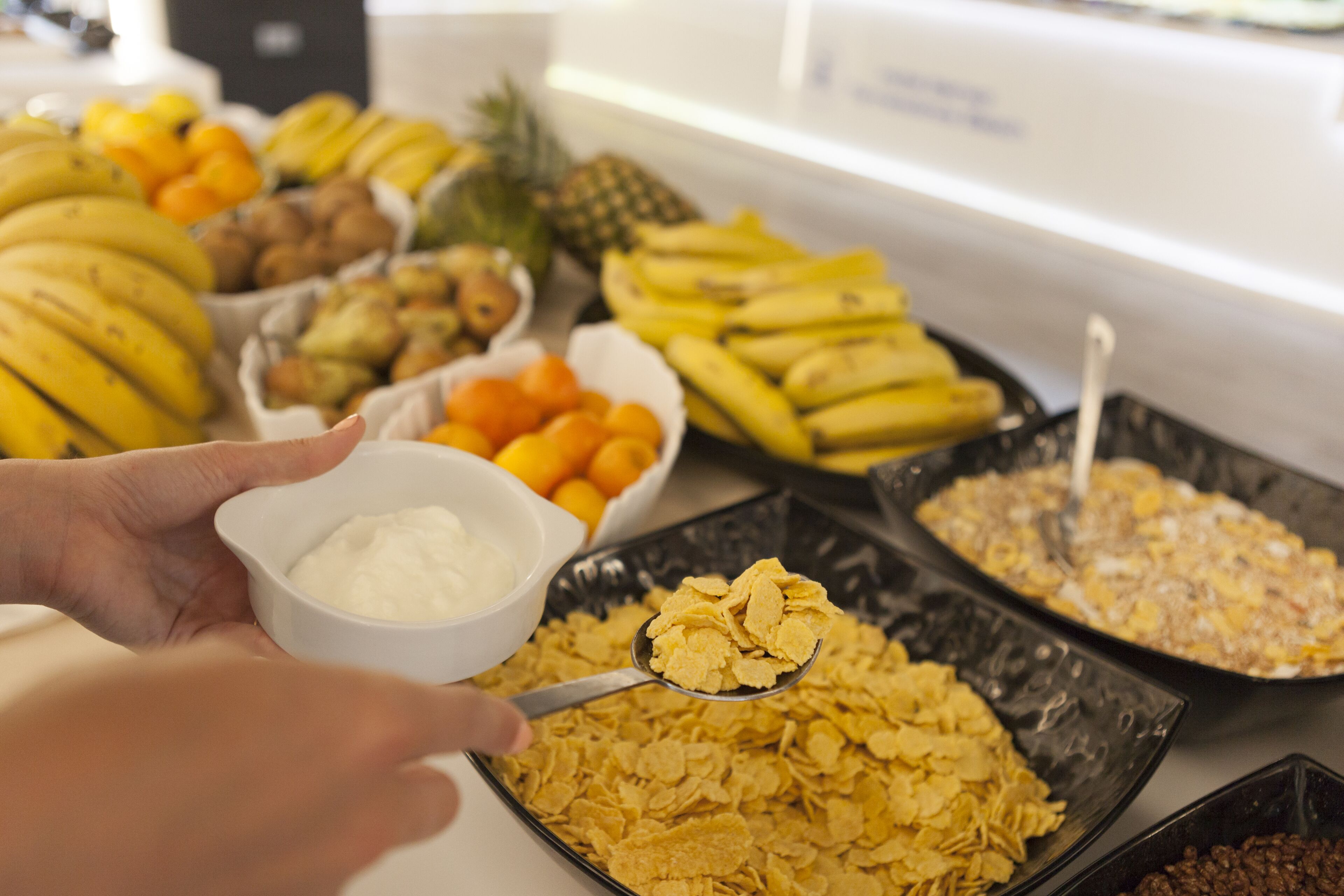 Un buffet proposant une variété d’aliments, notamment des fruits et des céréales.