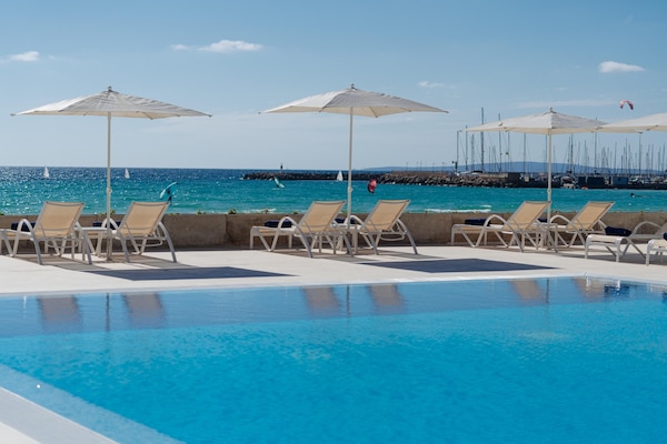 Una piscina techada, una piscina al aire libre de temporada, sombrillas