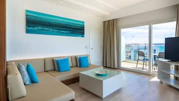 Una sala de estar moderna con un sofá, una mesa de centro y un amplio ventanal con vistas a la ciudad.