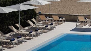 Inomhuspool, en säsongsöppen utomhuspool, parasoller och solstolar