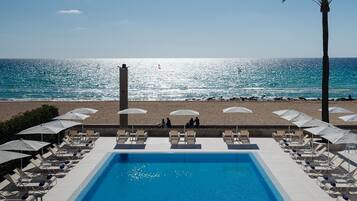 Une piscine avec vue sur la plage et l’océan.