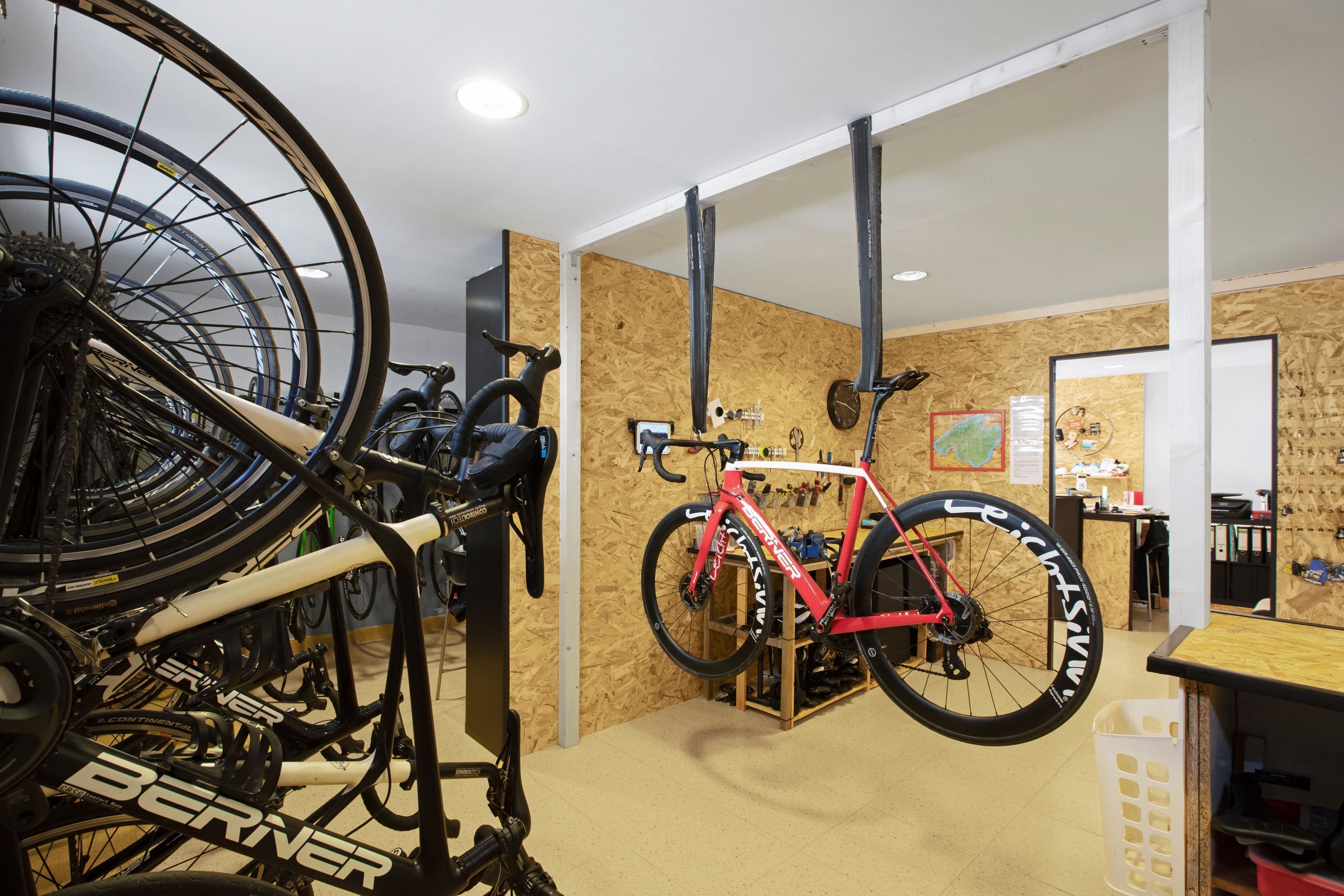 A room with bicycles, a wooden wall, and a whiteboard.