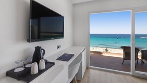 Una habitación moderna con una televisión de pantalla plana, una cafetera y una bandeja con tazas. Dispone de un balcón con vistas a la playa y al océano.