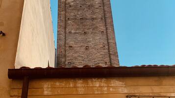 Een hoge bakstenen toren met bogen tegen een heldere lucht.